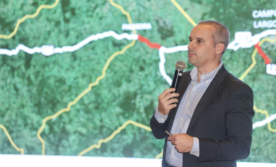 Homem falando no microfone em cima do palco