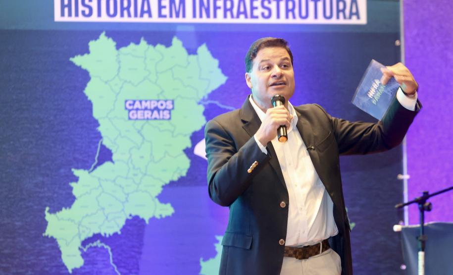 Homem falando no microfone em cima do palco