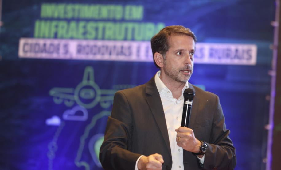 Homem falando no microfone em cima do palco