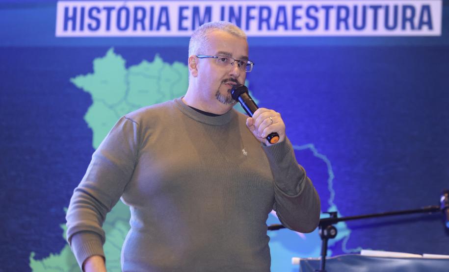 Homem falando no microfone em cima do palco