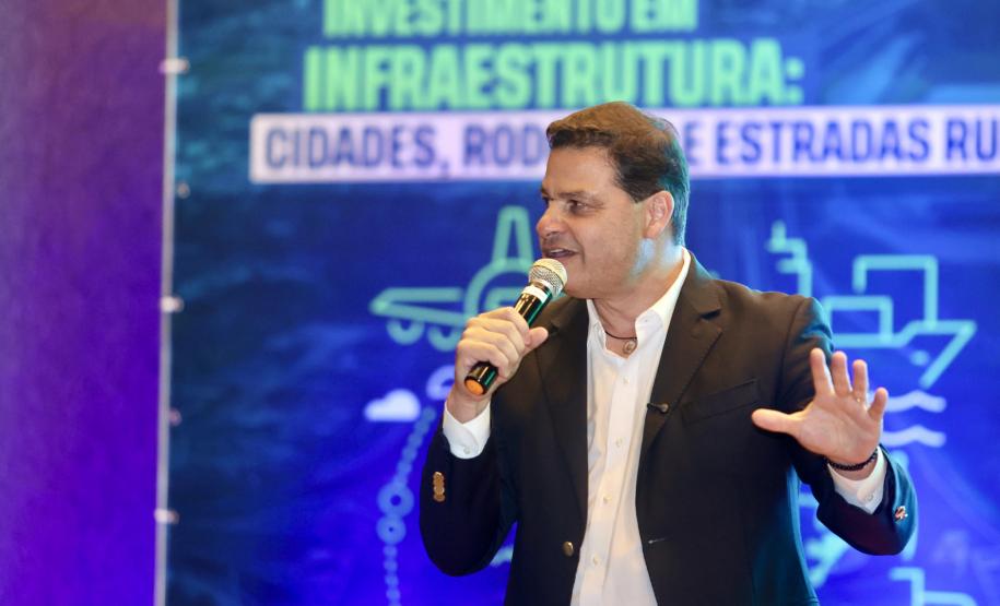 Homem falando no microfone em cima do palco