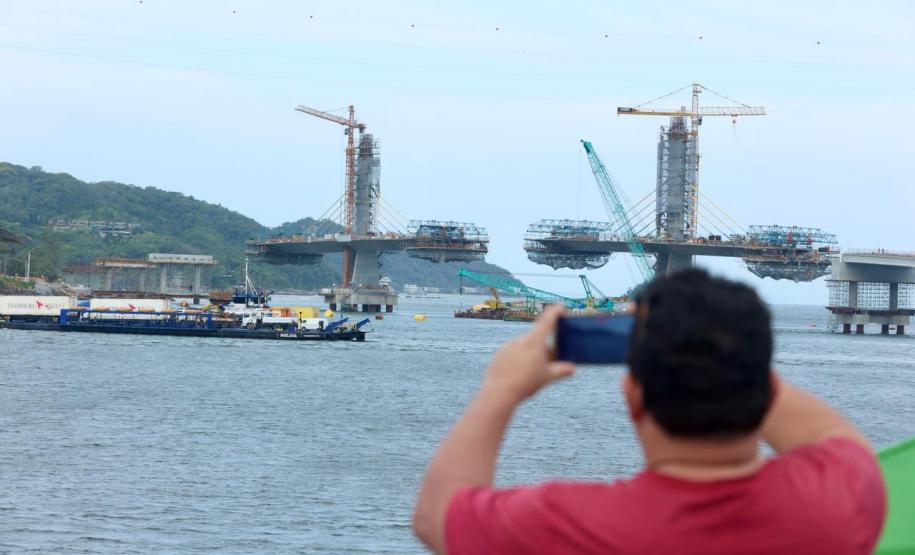 Pessoa tirando foto da obra da ponte de guaratuba